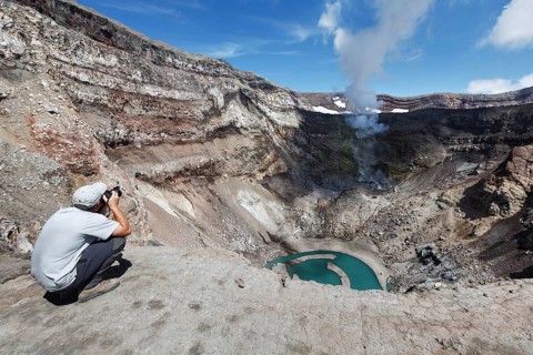 KAMCHATKA, RUSSIA, JULY 21, 2013: Tourist in the crater active Gorely Volcano shoot of the volcano