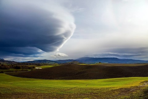 The thunderstorm begins. Picturesque hills of the legendary Tuscany. Beautiful Italy. Flat rows of