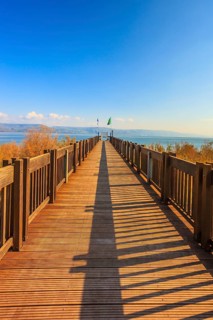 Wooden pier leading to the famous Sea of Galilee. Sunset on the lake of Kinneret