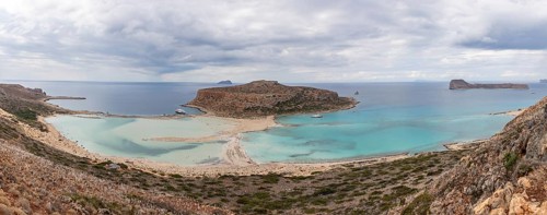 A panorama picture of the blue water of Balos Beach and the nearby landscape of the Gramvousa