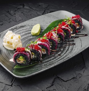 Food, Vibrant sushi rolls are arranged beautifully on a dark plate, showcasing various colors and
