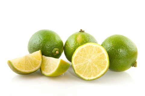 Fresh green limes cut isolated over white