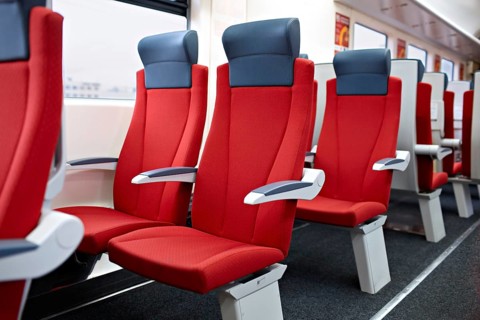 An interior view of a modern high speed train. Red chairs