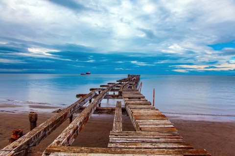 South America. Ruined ocean pier in Punta Arenas. The wooden dock flooring collapsed and rotted.