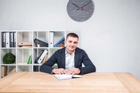 Portrait of a Caucasian male indoors posing in a jacket and white shirt. Overweight office worker