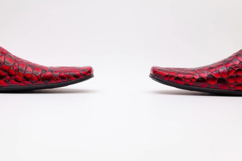 Detail of men's red shoes on white background