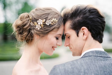 Smiling bride touches groom forehead with her forehead. Portrait.