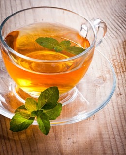 Mint tea in glass cup on wooden table