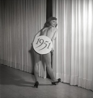 Ballet girl in the 1950s. A young woman on stage holding a sign with the year 1951 printed on it.