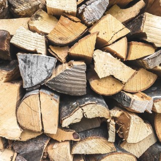 Firewood background. Stacked firewood in preparation for winter. Dry wood