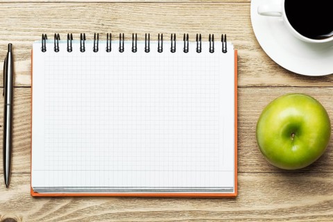 White blank paper with cup of coffee on wooden table