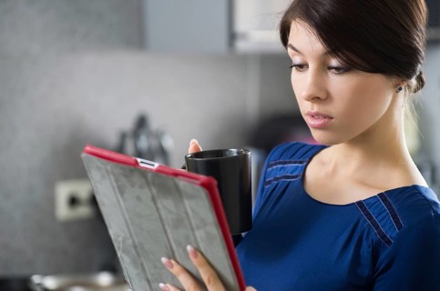 Portrait of young attractive caucasian brunette housewife at kitchen. Morning with cup of coffee