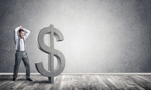 Young furious businessman going to crash with hands stone dollar symbol