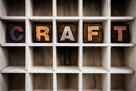 The word CRAFT written in vintage ink stained wooden letterpress type in a partitioned printer's