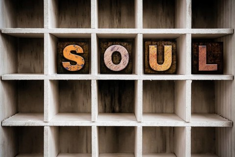 The word SOUL written in vintage ink stained wooden letterpress type in a partitioned printer's