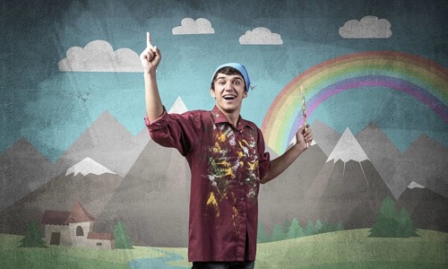Young male artist with paintbrush. Happy painter in shirt and bandana standing on background
