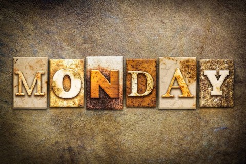 The word MONDAY written in rusty metal letterpress type on an old aged leather background