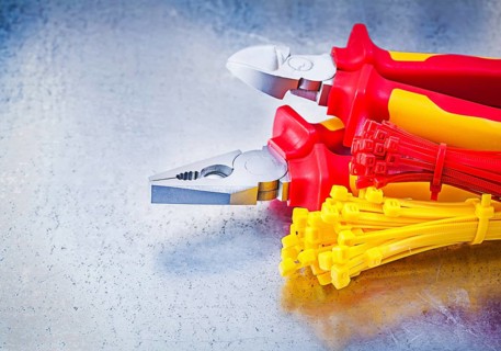 Nippers pliers self-locking cable ties on metallic background construction concept