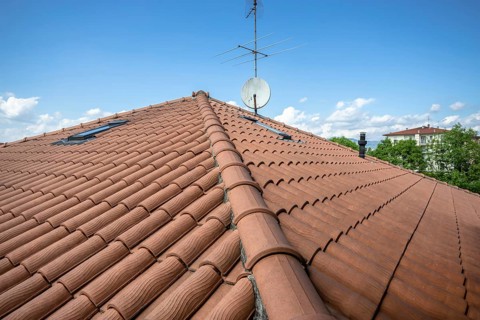 Red roof of the building against the blue sky. Copyspace for text, promotion or advertisement
