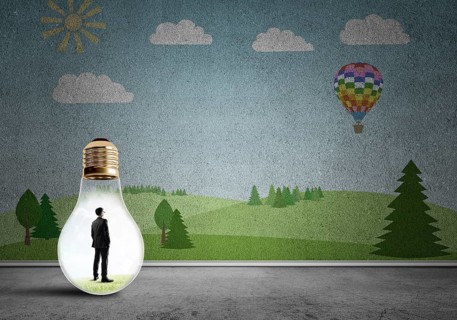 Businessman inside light bulb in room against nature drawn concept