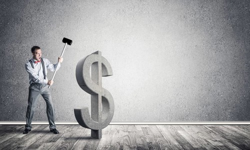 Young furious businessman going to crash with hammer stone dollar symbol