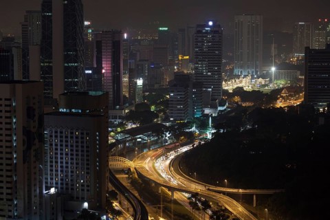 Night Kuala Lumpur, Malaysia. City architecture, train and car traffic on illuminated roads