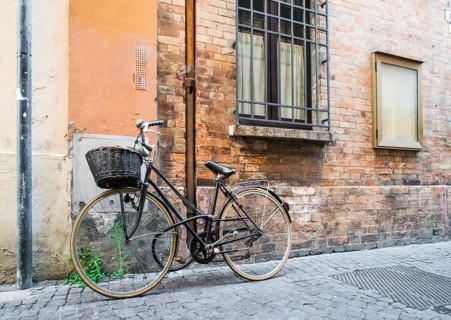 Old Italian bicycle on sunlight. Ancient buildings