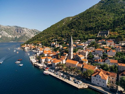 Drone view of the Perast coast with ancient houses and a tower. Montenegro.