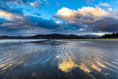 Low tide. Strips of sand and water left by the ocean tide. Sunrise over the ocean. New Zealand,