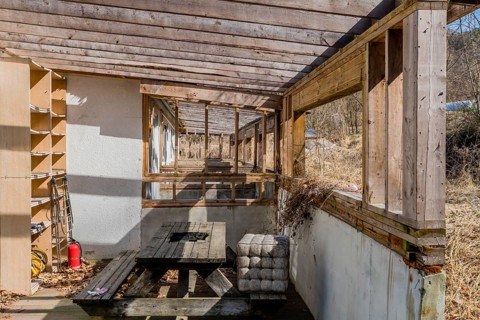 Chungju, South Korea, March 20, 2020: Back patio with decaying wooden picnic table at abandoned