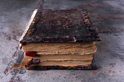 Ancient book, bible, Koran on a dark background