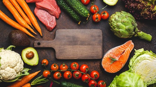 Assorted food raw products: vegetables, beef meat, fish salmon and empty wooden cutting board in