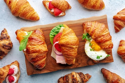 Croissant sandwich variety. Various stuffed croissants, overhead flat lay shot. Many rolls filled
