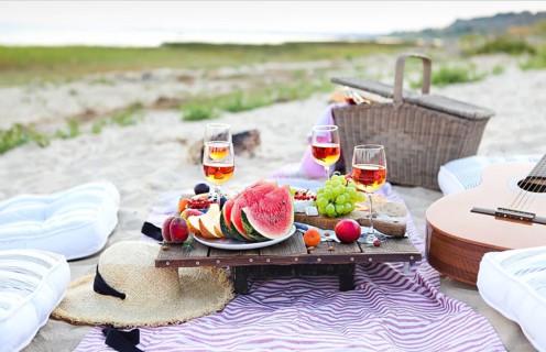 Picnic on the beach at sunset in the style of boho. Food and drink, relax, holiday concept