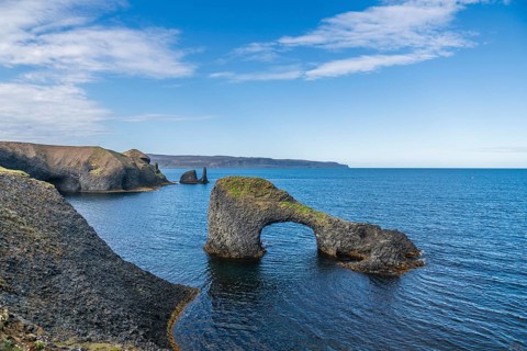 Rocky coast with Gatastakkur rock gate, Rauðanes peninsula, Norðurland eystra, Iceland