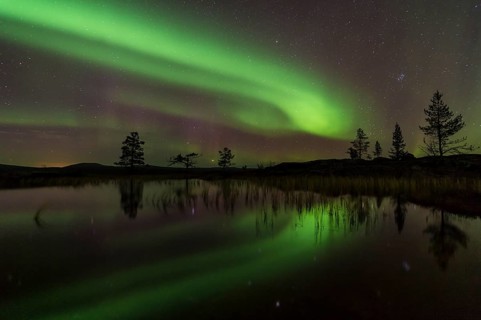 Northern Lights (Aurora borealis) reflected in a mountain lake, Gällivare, Norrbotten, Lapland,