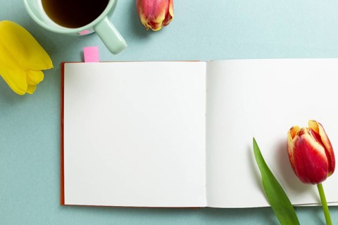 Empty note paper with tulip flowers, black coffee on mint green background. flat lay, top view,