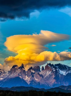 The black-and-steel color of the cliffs of Los Cuernos. Magnificent clouds in the rays of the