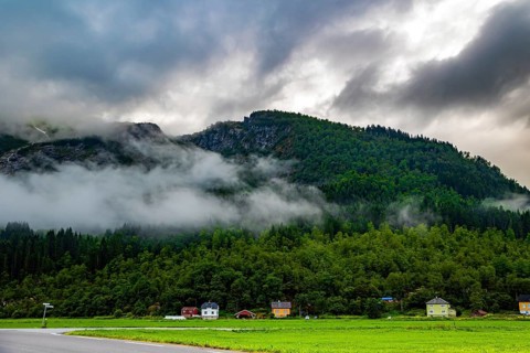 Lush green grass in the hollow. Jostedalsbreen Park. Cold summer in Norway. Valley surrounded by