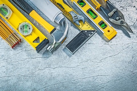 Assortment of construction tools on abstract metallic background building concept