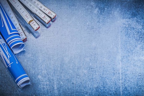 Blue blueprints wooden meter on metallic background copyspace construction concept