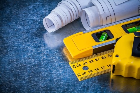 Ruler measuring tape construction level and blueprints on metallic scratched background building
