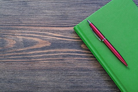 Notepad brio pen on wooden board office concept