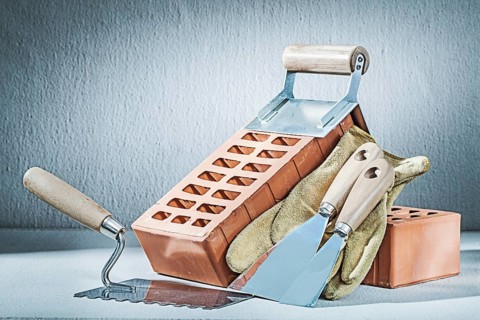 Trowels brick and gloves on concrette background