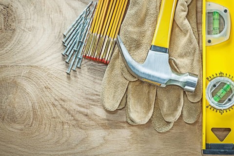 Construction level leather safety gloves wooden meter claw hammer nails on wood board building