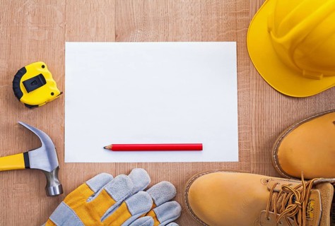Pencil paper helmet boots gloves hammer tapeline on wooden board organized copyspace