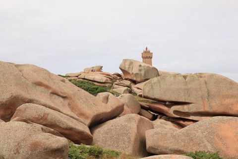 Granite boulder and lighthouse in Brittany, France