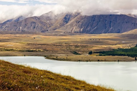 Lake Tekapo and the surrounding hills under clouds, South Island, New Zealand