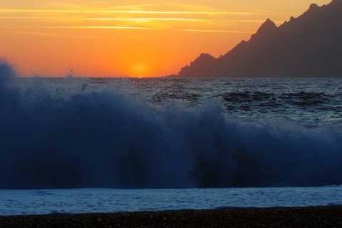 Surf wave at sunset on the beach in Porto, Corsica