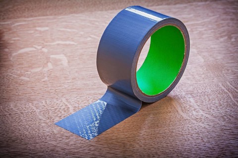 Unwound duct tape on vintage wooden board maintenance concept